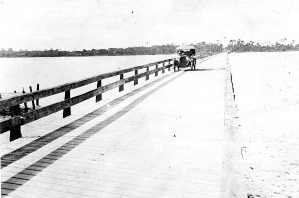 Car Driving Across Old Wooden Bridge